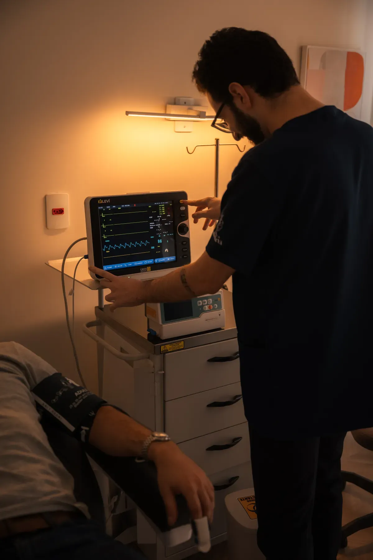 Médico verifica os sinais vitais no monitor durante a sessão